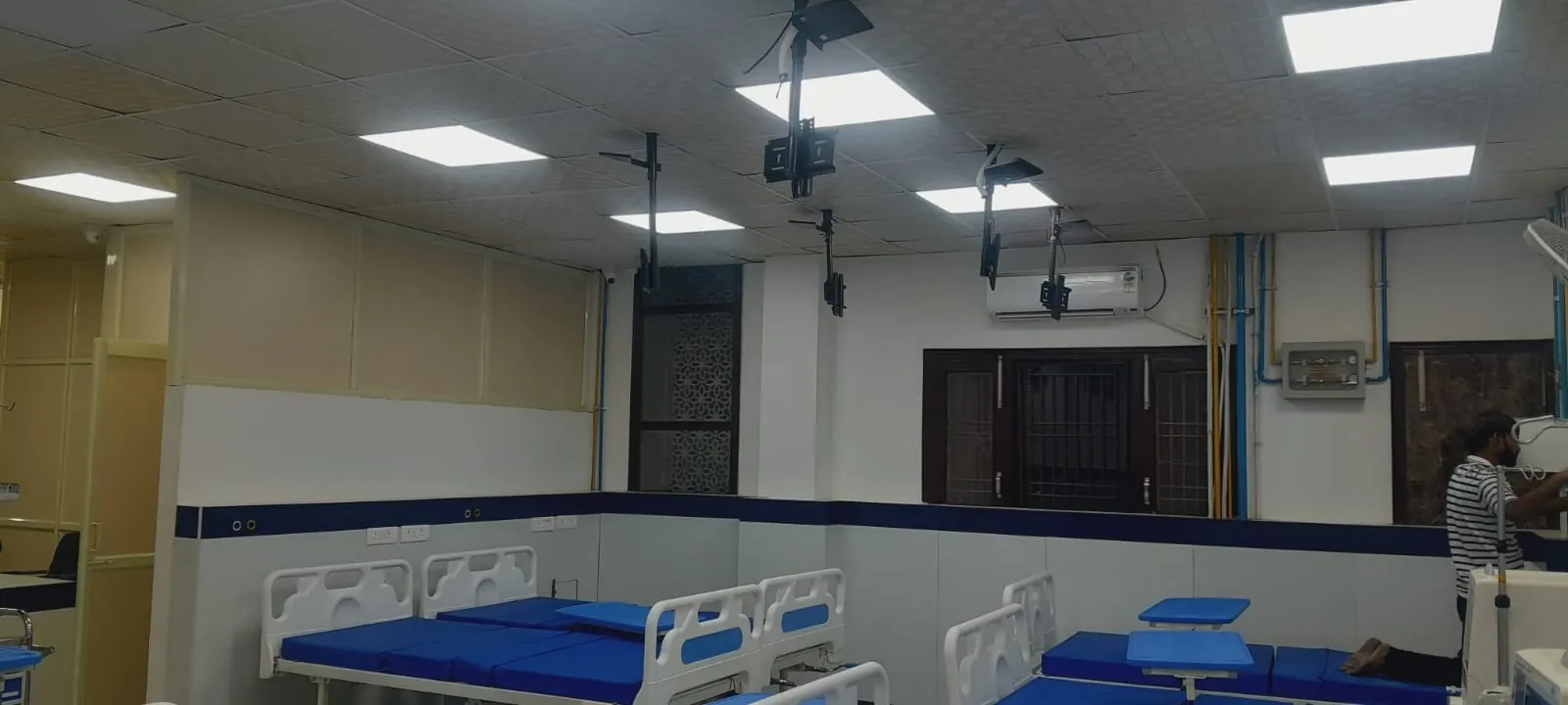 Hospital ward with patient beds, wall panelling and LED panel lights