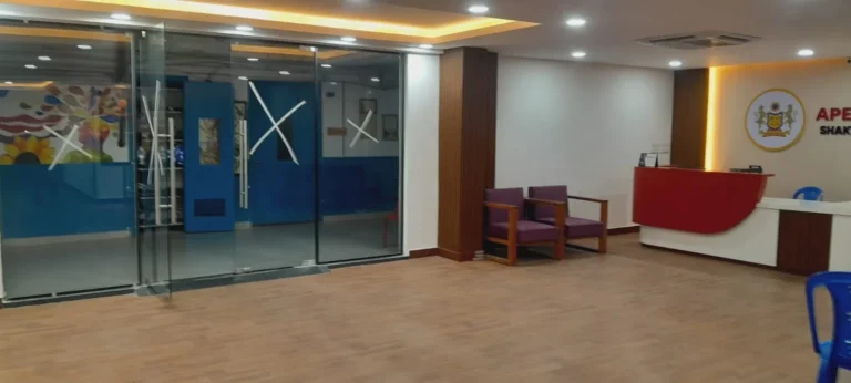Reception lounge with frameless glass partitions and ceiling cove lighting
